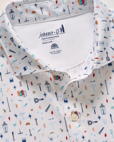 The Johnnie-O Bar Cart Big & Tall SS Polo is a white performance polo with a colorful, small-scale print of lanterns, keys, cocktails, and geometric shapes. It offers UPF 50 sun protection and moisture-wicking comfort. Brand: Johnnie-O.