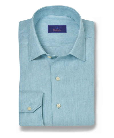 The David Donahue Herringbone Sport Shirt CBSM10100 is a light blue Pima cotton shirt with a herringbone weave, spread collar, cream buttons, and adjustable cuffs, shown neatly folded on a white background.
