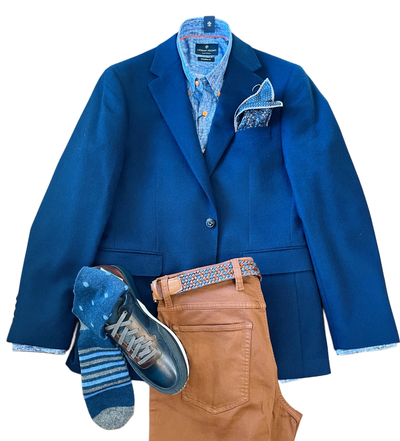 A men’s outfit featuring the Giles & Jasper Cashmere Coat Big&Tall by Giles & Jasper, a patterned shirt, pocket square, brown pants, blue sneakers, and striped socks—arranged flat on a white background.