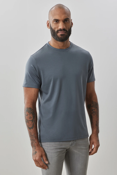 A bearded, tattooed man wears the Robert Barakett Georgia Tee Big & Tall 23336 in blue-gray and light gray jeans, standing against a neutral background.