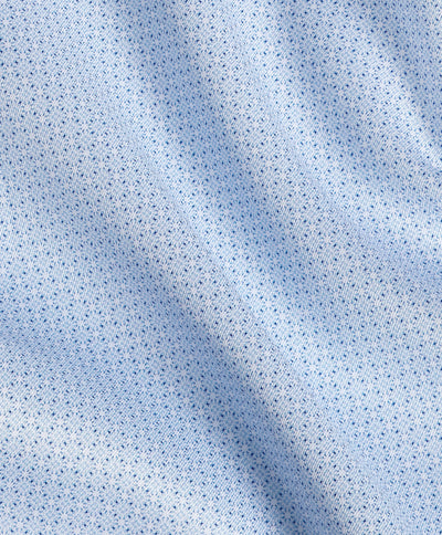 Close-up of light blue fabric from the David Donahue Micro Geometric Print Dress Shirt TBSP13203, featuring a small, repeating geometric pattern and slight folds that create soft shadows across the material.