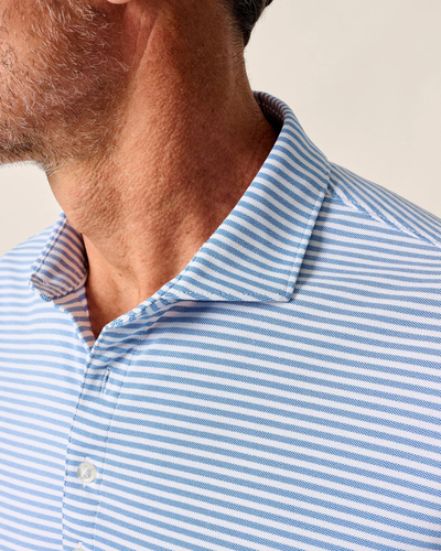 Close-up of a man’s neck and shoulder wearing the Johnnie-O Performance Polo- Stetsons, a light blue and white striped golf shirt by Johnnie-O, with his face partially out of frame.
