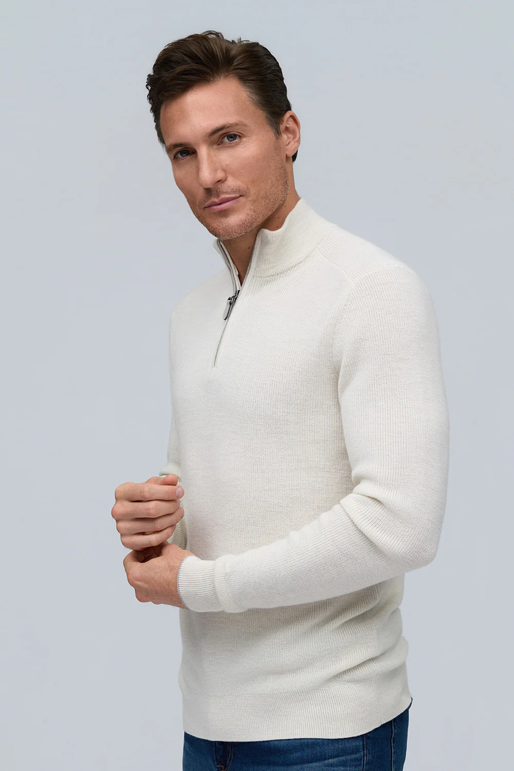 A man wears the Raffi Merino Zip Mock HWC12948-Z sweater with blue jeans, standing against a plain light background.