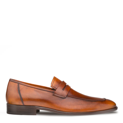 Showcased in a side profile against a white background, the Mezlan Calfskin Penny Loafer E20243 is a handcrafted men’s shoe made from supple brown calfskin leather. This loafer by Mezlan features a classic penny strap detail and a low wooden heel, exemplifying timeless sophistication.