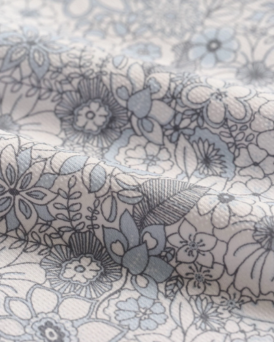 Close-up of the Johnnie-O Kayce Big&Tall Short Sleeve by Johnnie-O, featuring a knit button-up fabric with a detailed blue and grey floral pattern, soft folds, and textured surface.