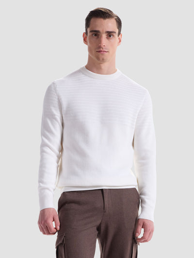 A man stands facing forward, wearing a Bugatchi Crew Neck Sweater HH521CN1 in white and brown cargo pants against a plain light gray background.