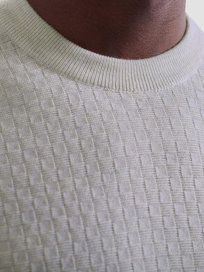 Close-up of a person wearing the Bugatchi Basketweave Crew Neck Sweater HH202CN1, a lightweight knit Merino wool sweater by Bugatchi featuring a textured basketweave design and ribbed collar.