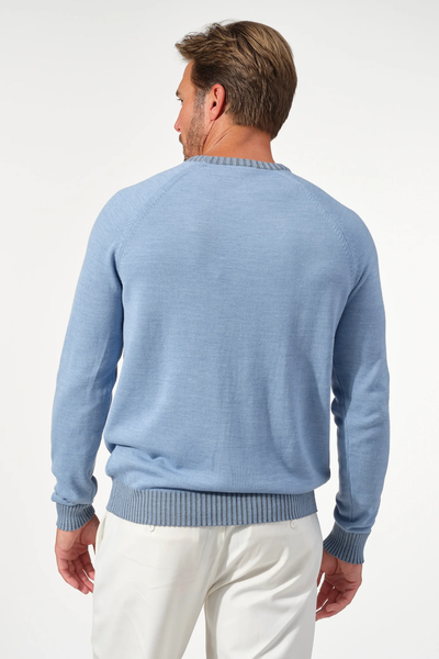 A man faces away, wearing the Garnet Crew Valmont Sweater 2522001CS by Garnet in light blue with white pants, set against a plain light background.