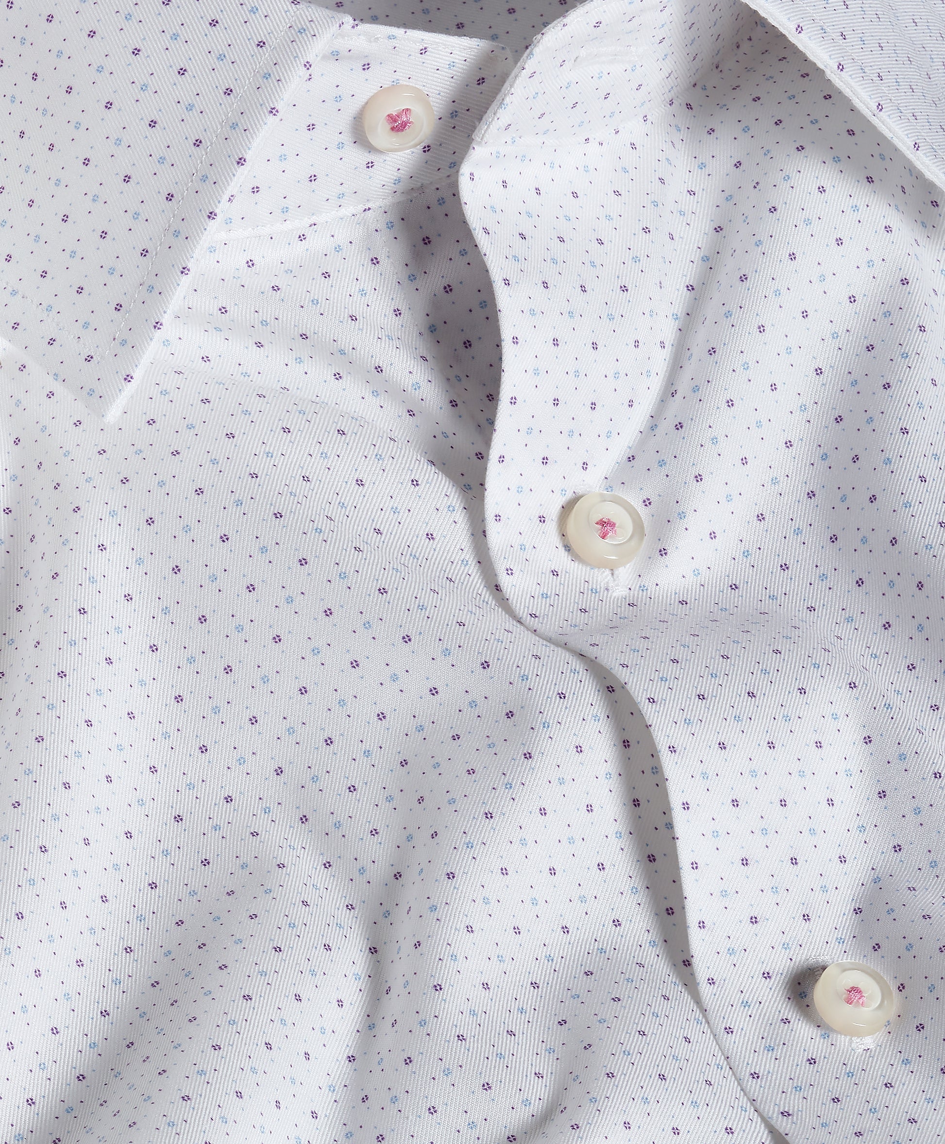 Close-up of the David Donahue Stretch Print Dress Shirt TBSP13200, a white Oxford weave shirt with subtle purple dots and cream buttons, showcasing a gently wrinkled texture and unbuttoned collar—a refined piece from David Donahue.