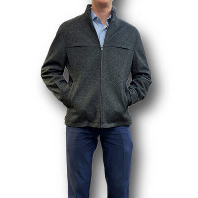 A man wearing an Enzo Enzo Coat Play over a light blue collared shirt and navy pants stands with his hands in his pockets.