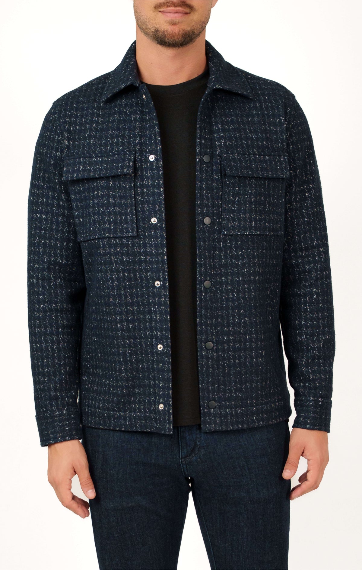 A man wearing a navy blue Stone Rose Hunter Knit Houndstooth Jacket with two chest pockets and metal snap buttons over a black t-shirt.
