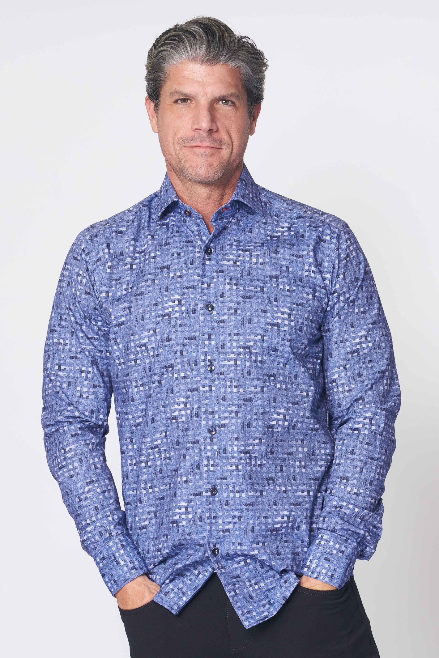 A man stands with hands in pockets against a light background, wearing the 7 Downie St. Sport Shirt Big & Tall 6 LS by 7 Downie St—a navy, tailored-fit long-sleeve shirt.