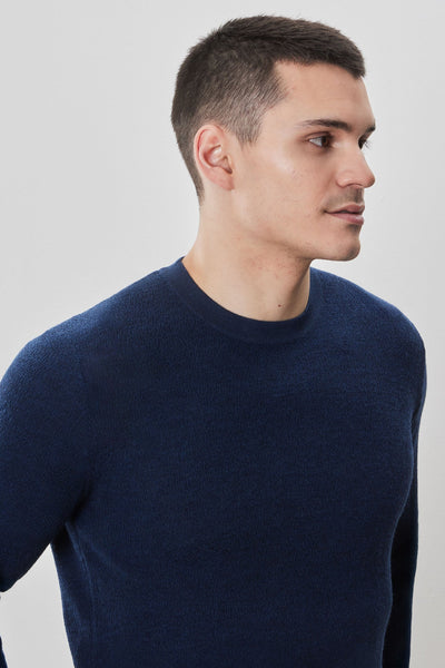 A man with short dark hair wears the Robert Barakett Watertown Sweater by Robert Barakett and looks to the right against a plain light background.