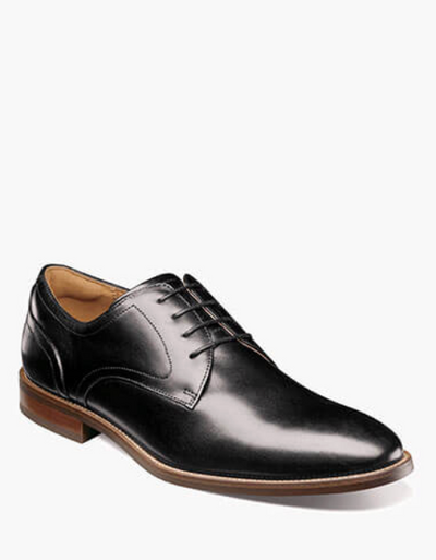 The Florsheim Rucci Plain Toe Oxford by Florsheim is a black leather oxford with a brown sole, closed laces, and a polished finish, shown against a white background.