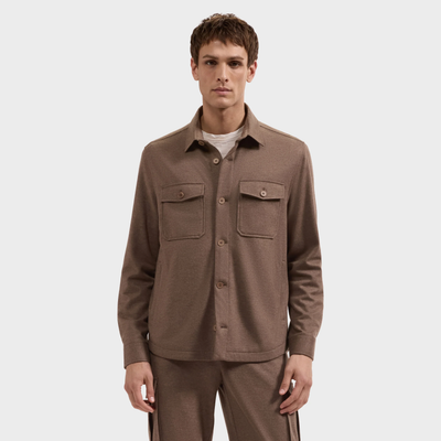 A man stands facing forward against a plain background wearing the Bugatchi Button Shirt Jacket KX9015JS1 in light brown with two chest pockets and matching pants.