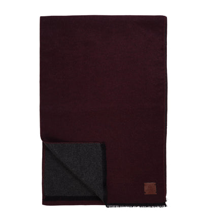 The Amanda Christensen Double Face Scarf 440714 features a burgundy exterior, dark gray interior, small brown patch in one corner, and elegant fringed edges for a sophisticated look.