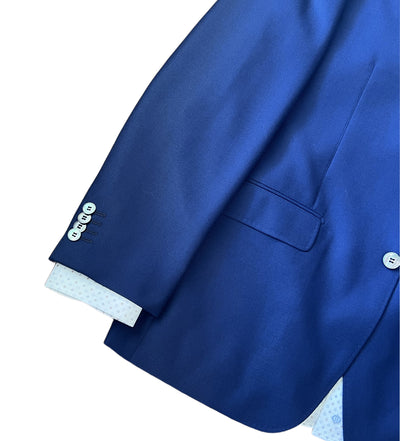 A close-up of the right sleeve and side pocket of the Byron Luxe Sport Coat 8011 by Byron in French blue, featuring three buttons on the textured sleeve and white shirt cuffs peeking out.