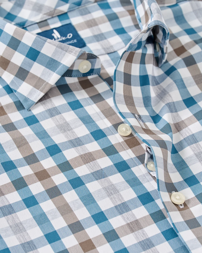 Close-up of the Johnnie-O Cay Exploded Gingham Shirt Big & Tall by Johnnie-O, showcasing a blue, brown, and white plaid pattern with white buttons and a structured collar. This moisture-wicking performance shirt combines comfort and style for all-day wear.