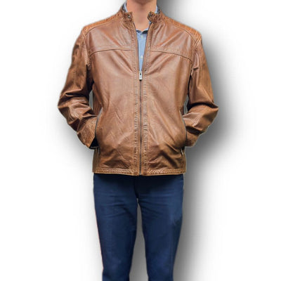 A person wearing a Missani Leather Jacket 392834 over a blue shirt and navy pants stands with hands in jacket pockets against a white background.