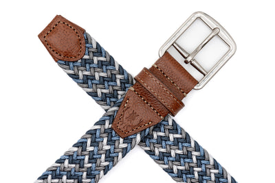 The Martin Dingman Newport Braided Elastic Belt features blue, gray, and white woven Italian rayon with brown leather and a silver buckle on a white background.