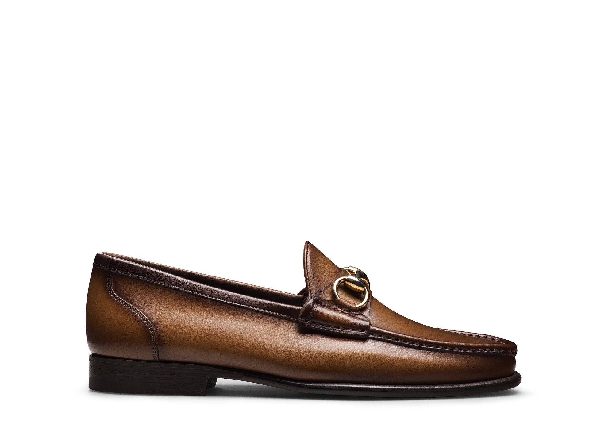 The Magnanni Giancarlo Moc Toe Bit Loafer by Magnanni is a brown leather loafer featuring a low heel, gold horsebit detail on the upper, and hand-stitched accents. Displayed in profile against a white background, this classic shoe adds timeless elegance to the modern wardrobe.