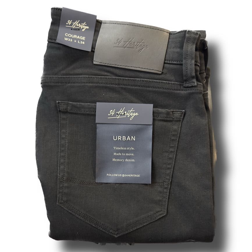 A folded pair of 34 Heritage Courage Black Urban Jeans, tagged W33 L34, showcases premium denim and timeless style in a straight leg fit.