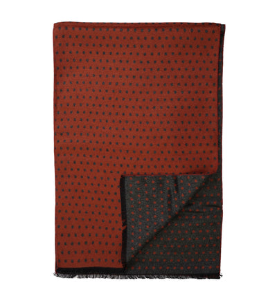The Amanda Christensen Double Face Dot Scarf 440614 features a rust-red side with black dots, a dark gray reverse with red dots, and short fringe edges. Folded corners reveal both patterns for versatile styling.