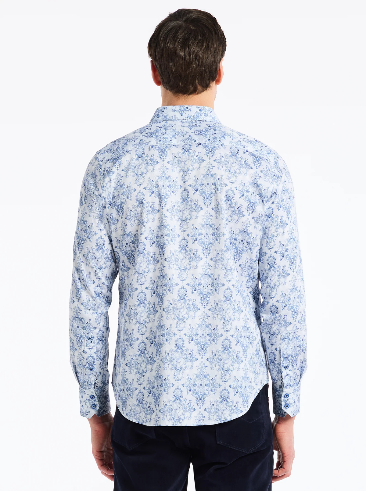 A man with short brown hair is shown from the back wearing the Robert Graham Delancey Woven L/S Shirt B&T by Robert Graham, which features a light blue and white floral allover print, styled with dark pants against a white background.