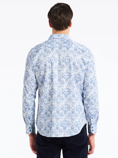 A man with short brown hair is shown from the back wearing the Robert Graham Delancey Woven L/S Shirt B&T by Robert Graham, which features a light blue and white floral allover print, styled with dark pants against a white background.