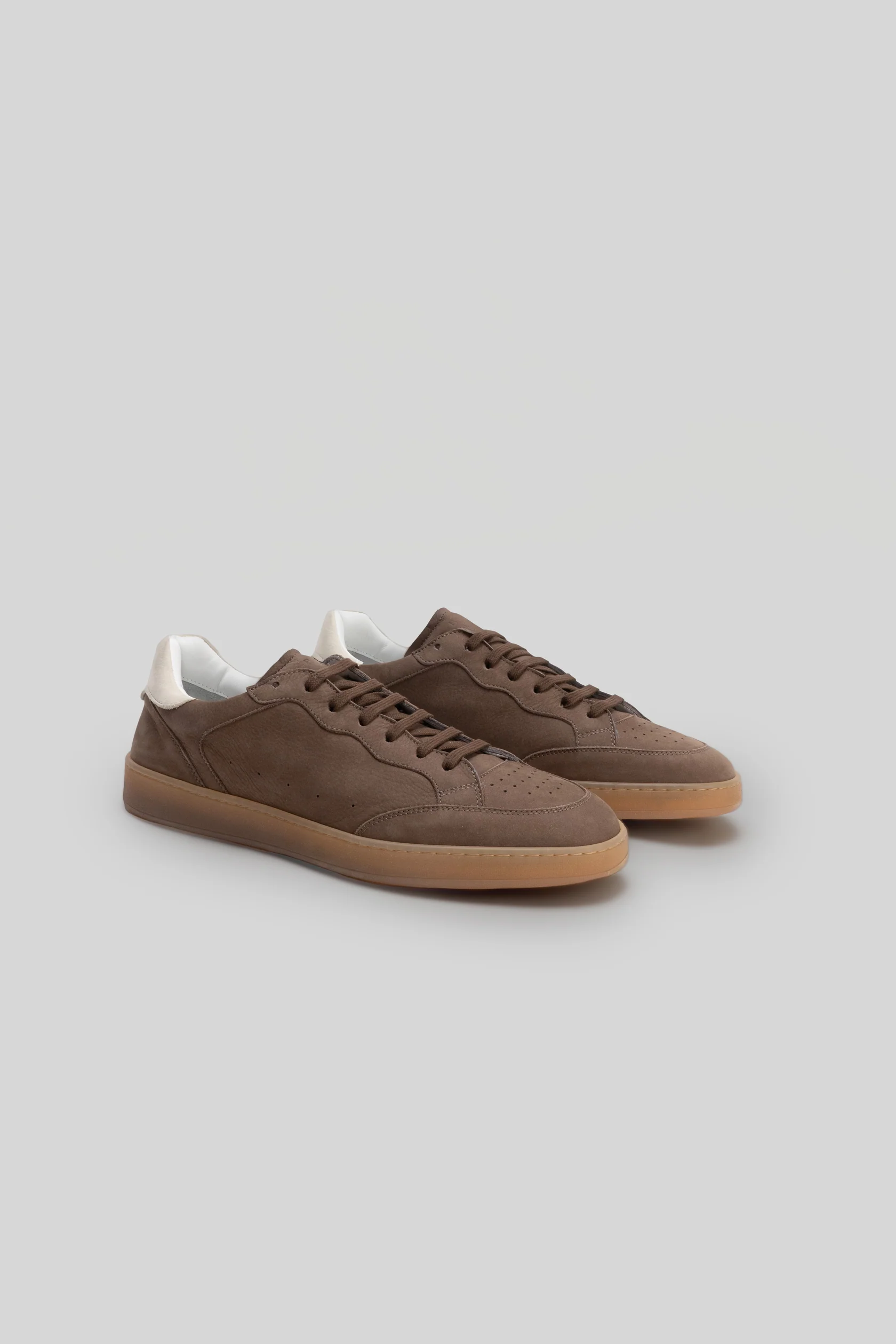 The Robert Barakett Rodney Court Sneaker by Robert Barakett is a pair of brown Italian leather sneakers featuring gum rubber soles and white heel accents, shown against a plain light gray background.