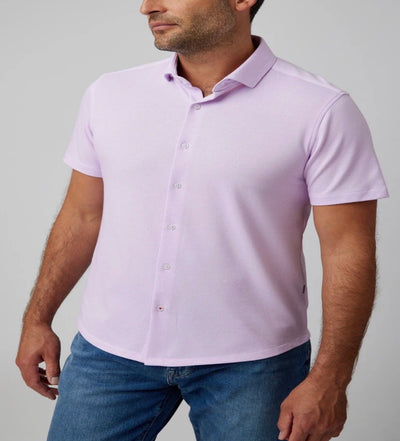 A man wearing a light purple Stone Rose SS Pique Shirt 2K7T241 and blue jeans stands against a plain gray background.