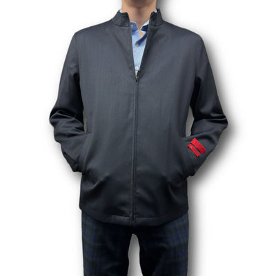 A person wears the Mattarazi Coat Paolo by Mattarazi over a light blue shirt, hands in pockets, with a red tag visible on the left sleeve.