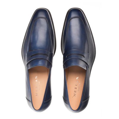 A pair of Mezlan Calfskin Penny Loafer E20243 in blue calfskin leather features a square toe as seen from above. These handcrafted men's loafers by Mezlan display tan insoles branded with the Mezlan logo in gold, exemplifying the quality and elegance of premium calfskin leather footwear.
