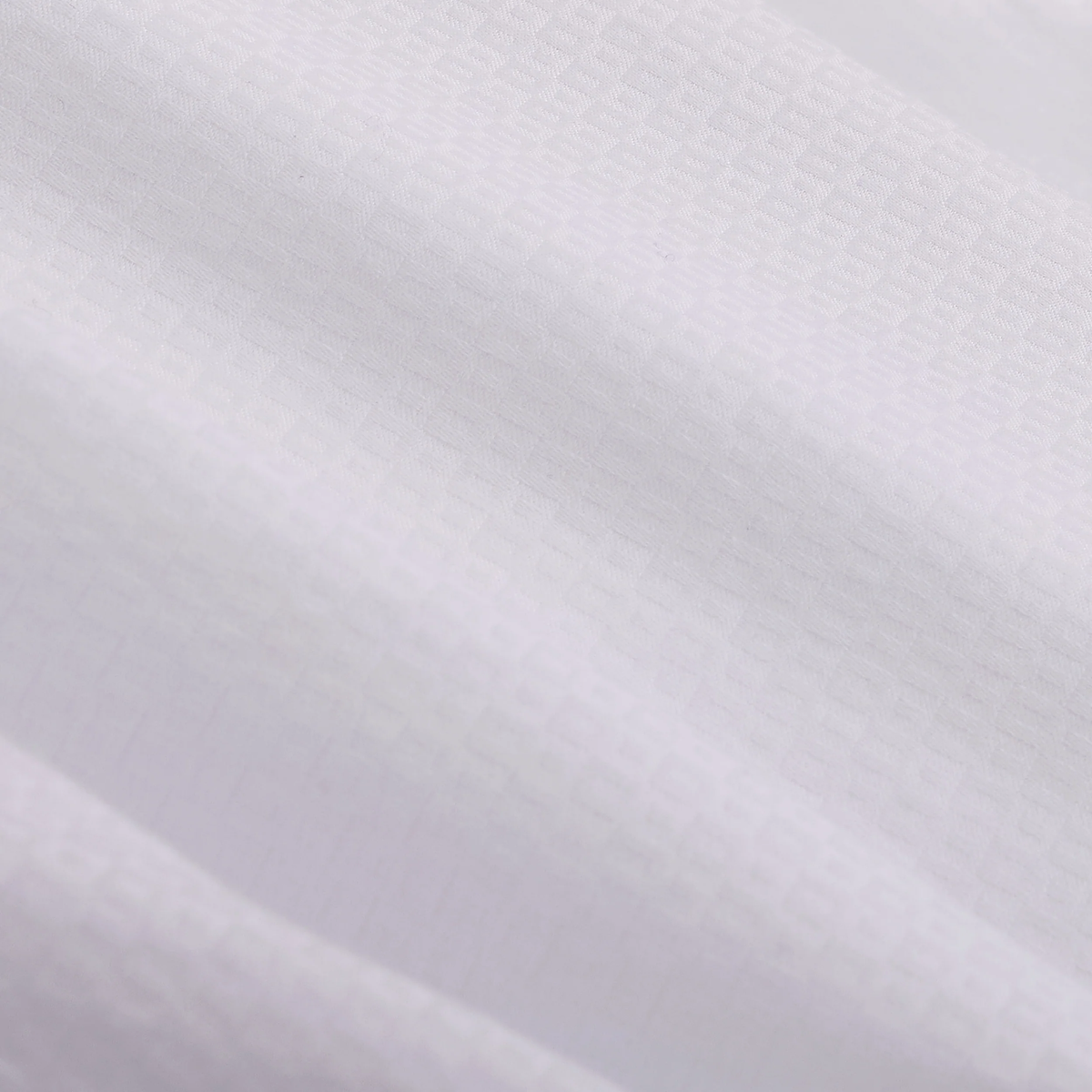 Close-up of white Bugatchi Julian Tonal Geometric Jacquard Shirt fabric featuring a subtle tonal geometric jacquard pattern and gentle, wavy folds that highlight its wrinkle-resistant qualities.