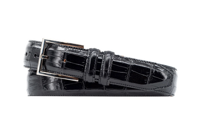 The Martin Dingman Alexander Alligator Leather Belt in black features a silver rectangular buckle and is neatly rolled against a white background.