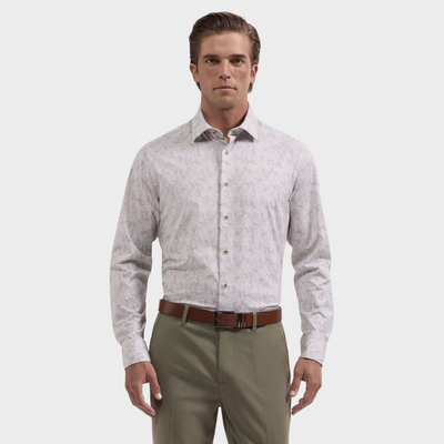 A man stands facing forward against a plain white background, wearing the Bugatchi James Feather Print Sport Shirt (style KF9234K60) by Bugatchi, paired with a brown belt and green trousers.