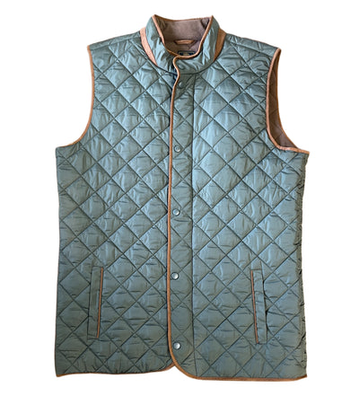 The F/X Fusion Quilted Field Vest features a light blue color, snap buttons, two front pockets, and tan trim along the edges and collar—an essential men's outerwear piece by F/X Fusion shown on a white background.