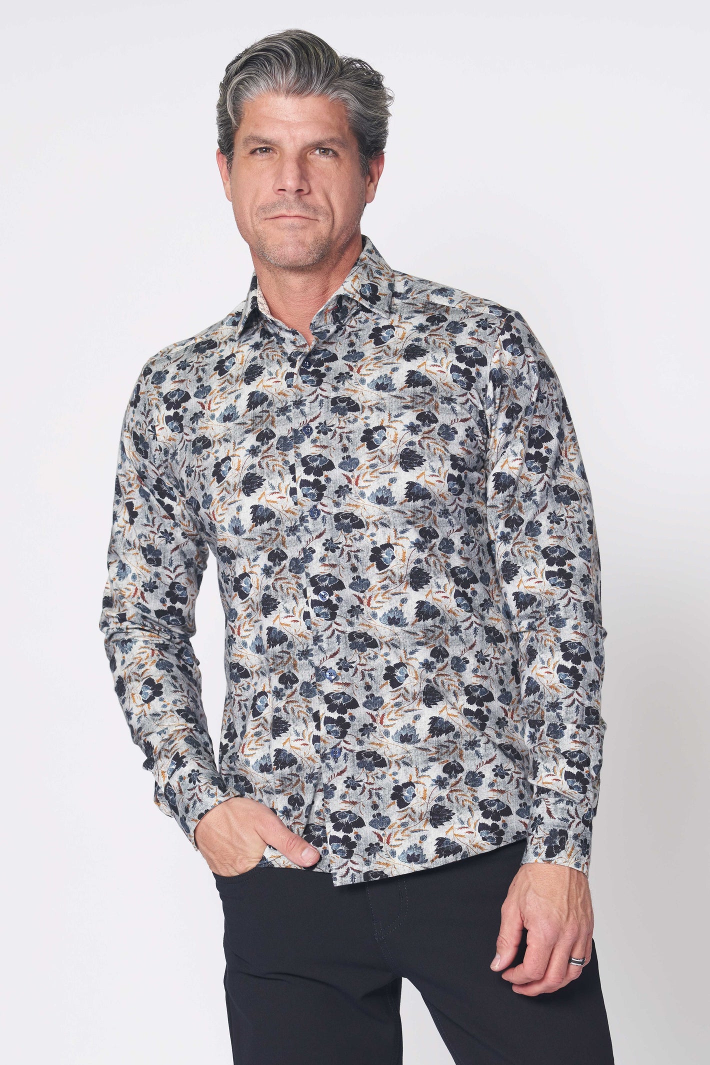 Man wearing the 7 Downie St. Amore Big & Tall Sport Shirt Multi by 7 Downie St, featuring a tailored fit and floral pattern in dark and light blue, standing against a plain white background.