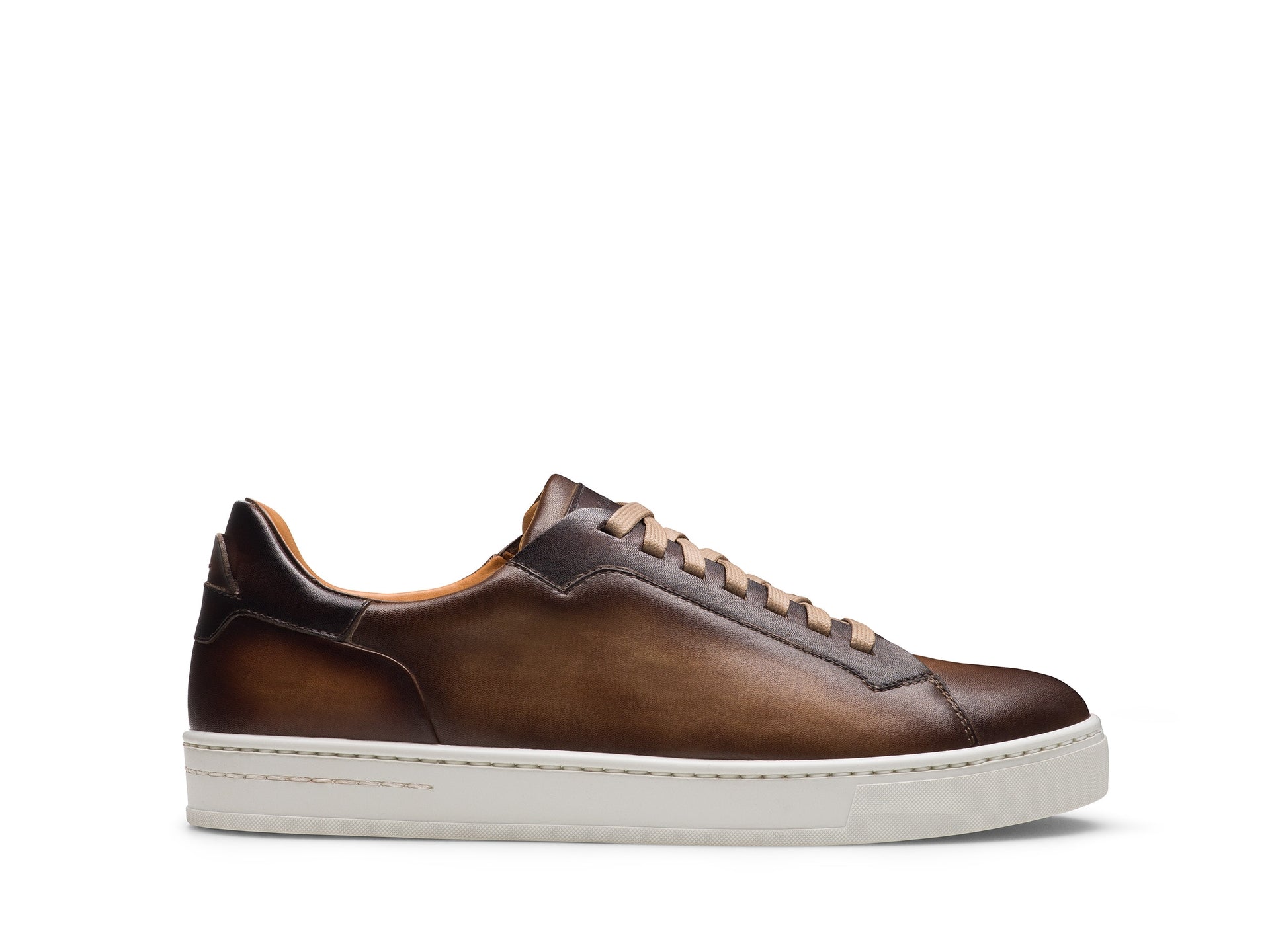 The Magnanni Amadeo Sneaker by Magnanni is a brown leather low-top with a leather toe, tan laces, and a white rubber sole, shown in a side view against a white background.