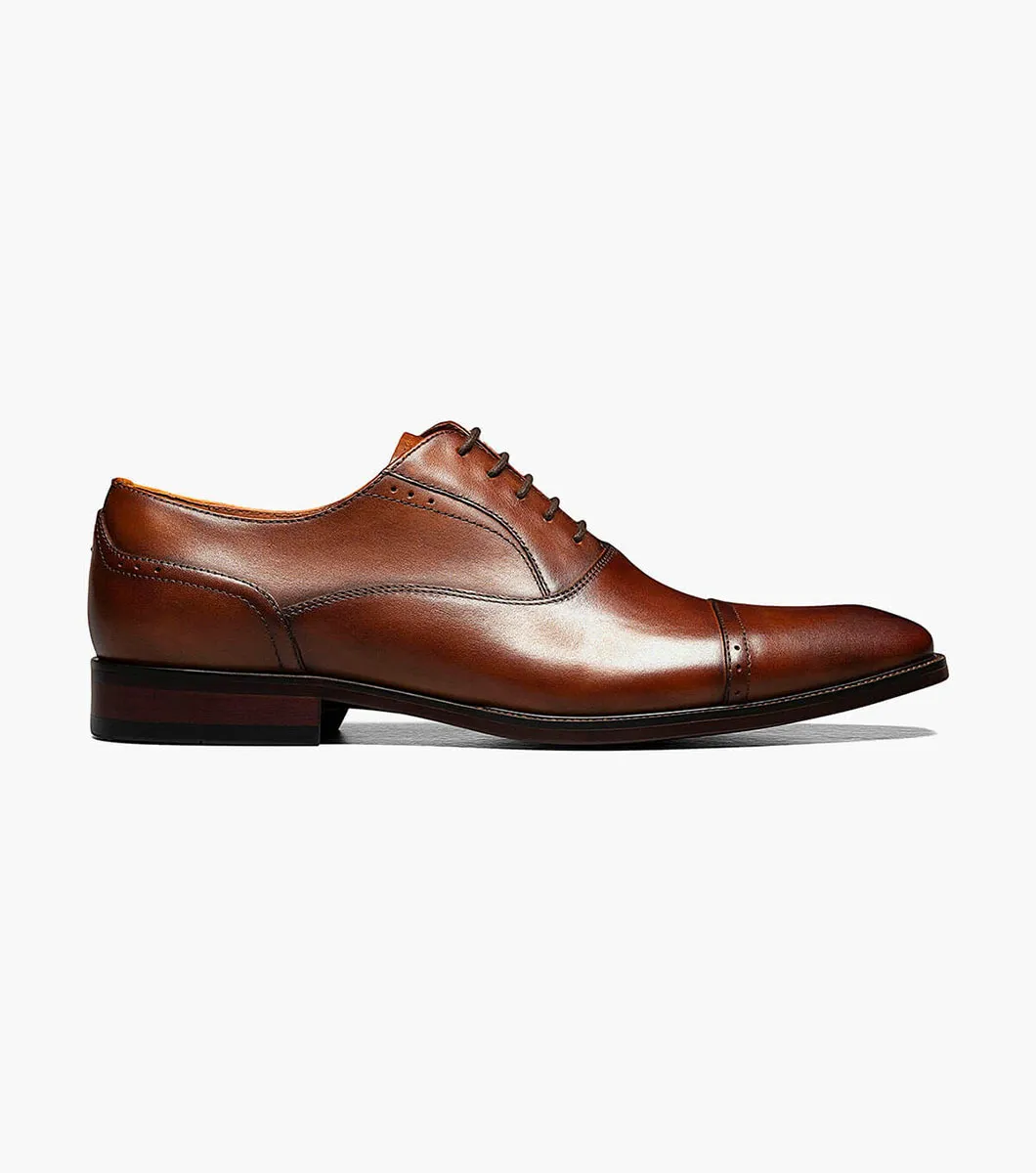 The Florsheim Sorrento Cap Toe Oxford, a brown leather dress shoe by Florsheim featuring a cushioned footbed, is shown in side view against a plain white background.