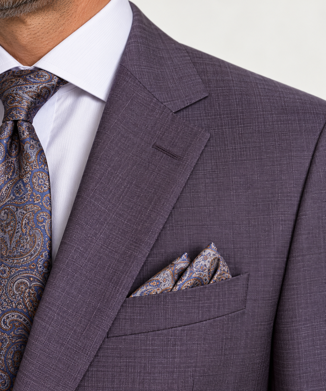 Jack Victor Napoli Suit Plum 3262603 jacket worn with a white dress shirt, a blue and gold paisley tie, and a matching paisley pocket square.