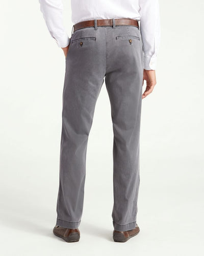 A person is standing with their back to the camera, dressed in a white shirt, brown belt, brown shoes, and gray Tommy Bahama Boracay Pant Big & Tall trousers.