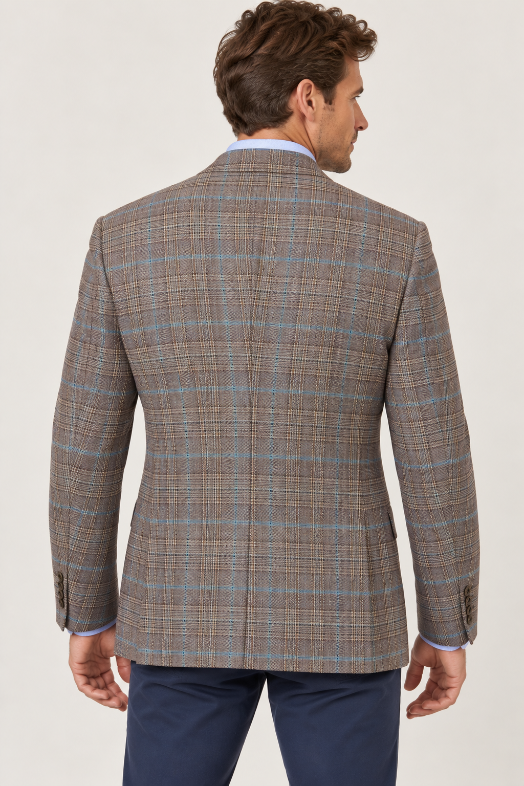 Back view of a man wearing a brown plaid Jack Victor Conway Brown Plaid Sport Coat 1262312 with blue windowpane accents over a light blue dress shirt and navy trousers.