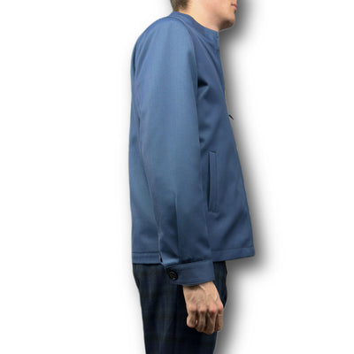A person in a blue Mattarazi Coat Paolo by Mattarazi and dark plaid pants, shown from the side against a white background.