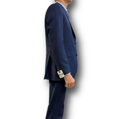 A person in profile wears the Jack Victor Sport Coat Blue 161150 by Jack Victor against a white background, with a tag hanging from the sleeve of the 100% wool jacket.