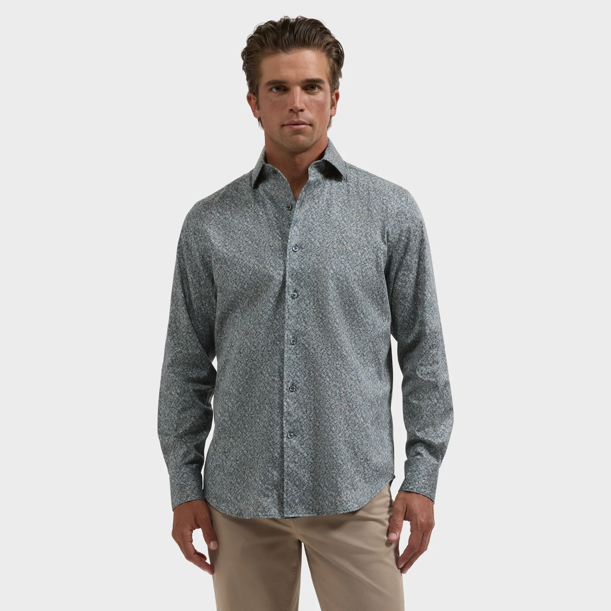 A man wearing the Bugatchi Alvin Floral Sport Shirt and beige pants stands against a plain white background.
