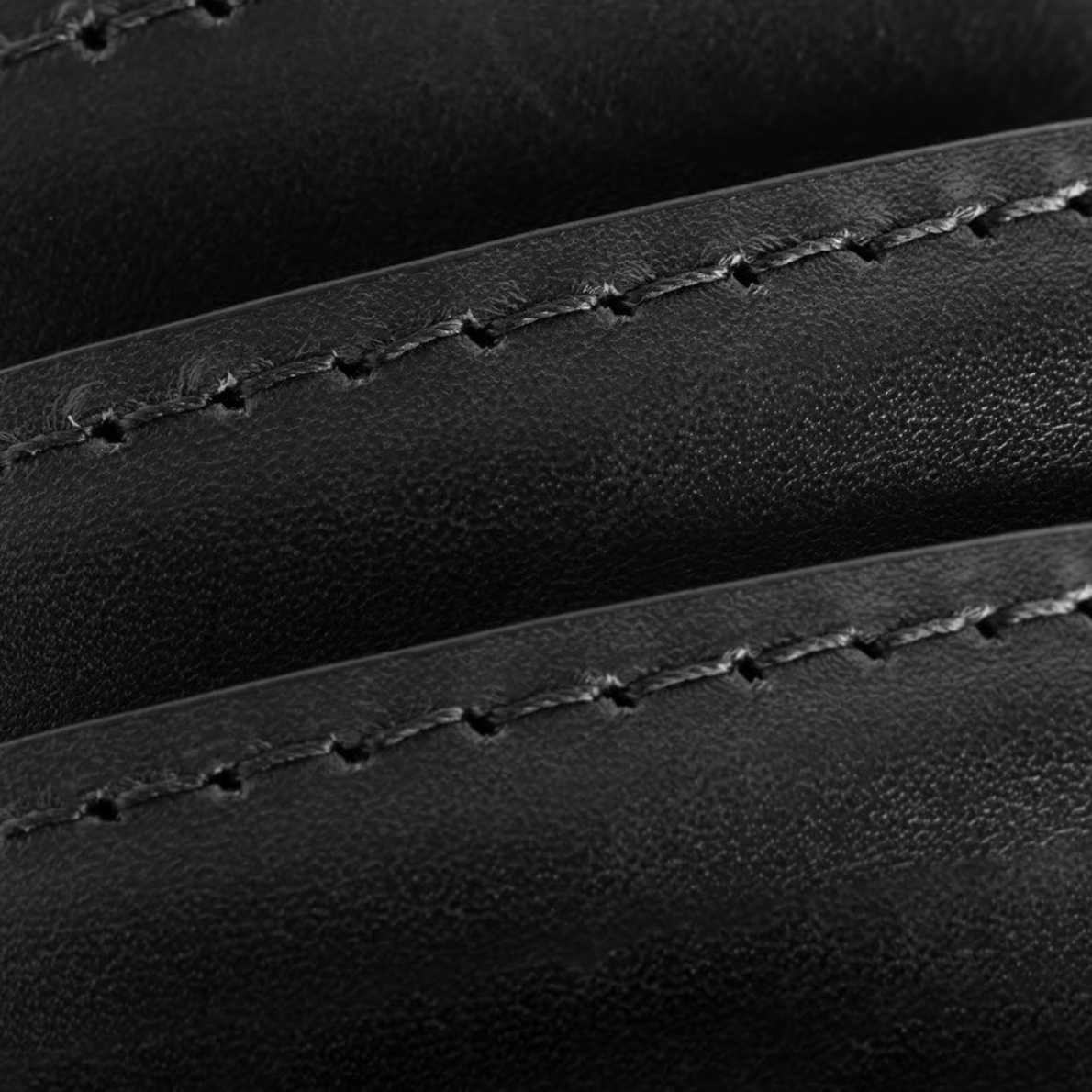 Close-up of black Italian calfskin leather on the Allen Edmonds Wide Basic Belt, with visible parallel curved stitching that highlights the rich texture and expert craftsmanship of this finely handcrafted-in-America dress belt by Allen Edmonds.