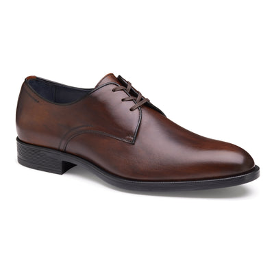 The Johnston & Murphy Flynch Plain is a brown leather dress shoe with Italian hand-stained uppers, black sole, lace-up closure, leather linings, and a slightly pointed toe from Johnston Murphy, shown on a white background.