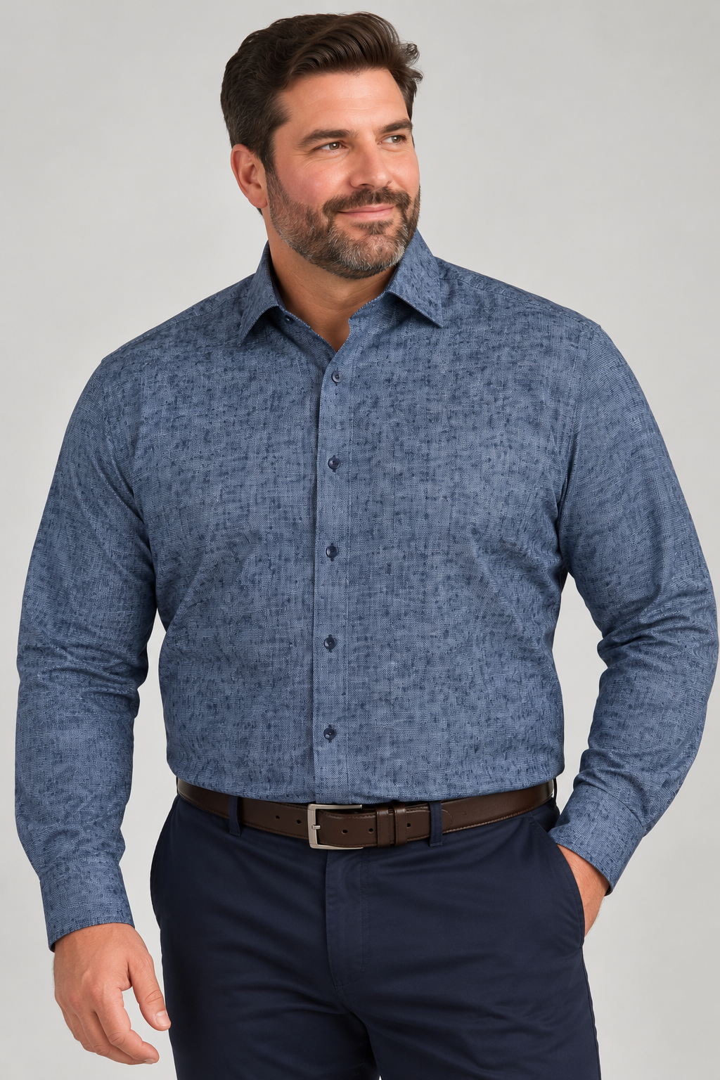 A man wears a 7 Downie St. Silktouch Sport Shirt Big & Tall F266 in a blue and red medallion pattern, tucked into navy trousers with a brown leather belt.