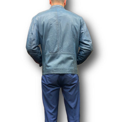 A man stands with his back to the camera, wearing a blue Missani Leather Jacket 392834 and blue pants against a white background.